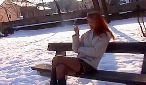 Exibition d’une jolie rouquine sur un banc public