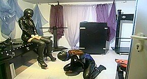 Slave in latex dress in kneeling