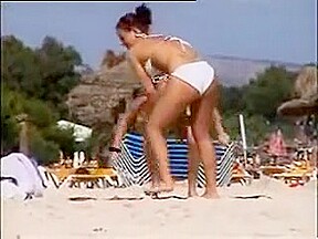 Deux copines topless simulent de baiser sur la plage