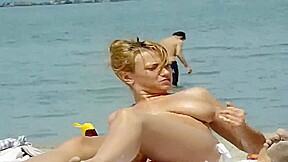 Elle masse ses gros seins sur la plage pour seduire