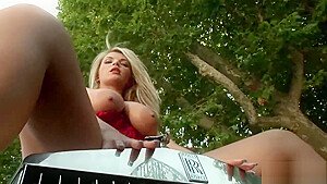 Girl with big tits poses on a car